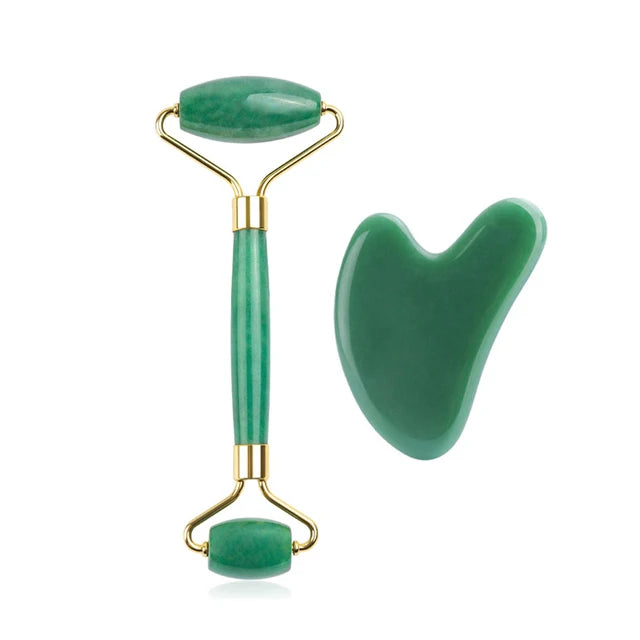 Green jade roller and gua sha tool on a white background