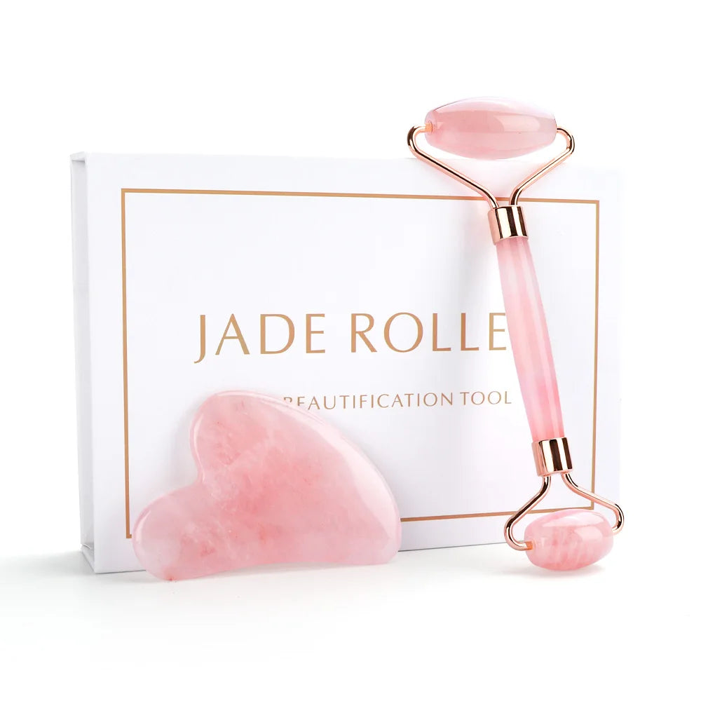 Pink jade roller and gua sha tool with packaging on a white background